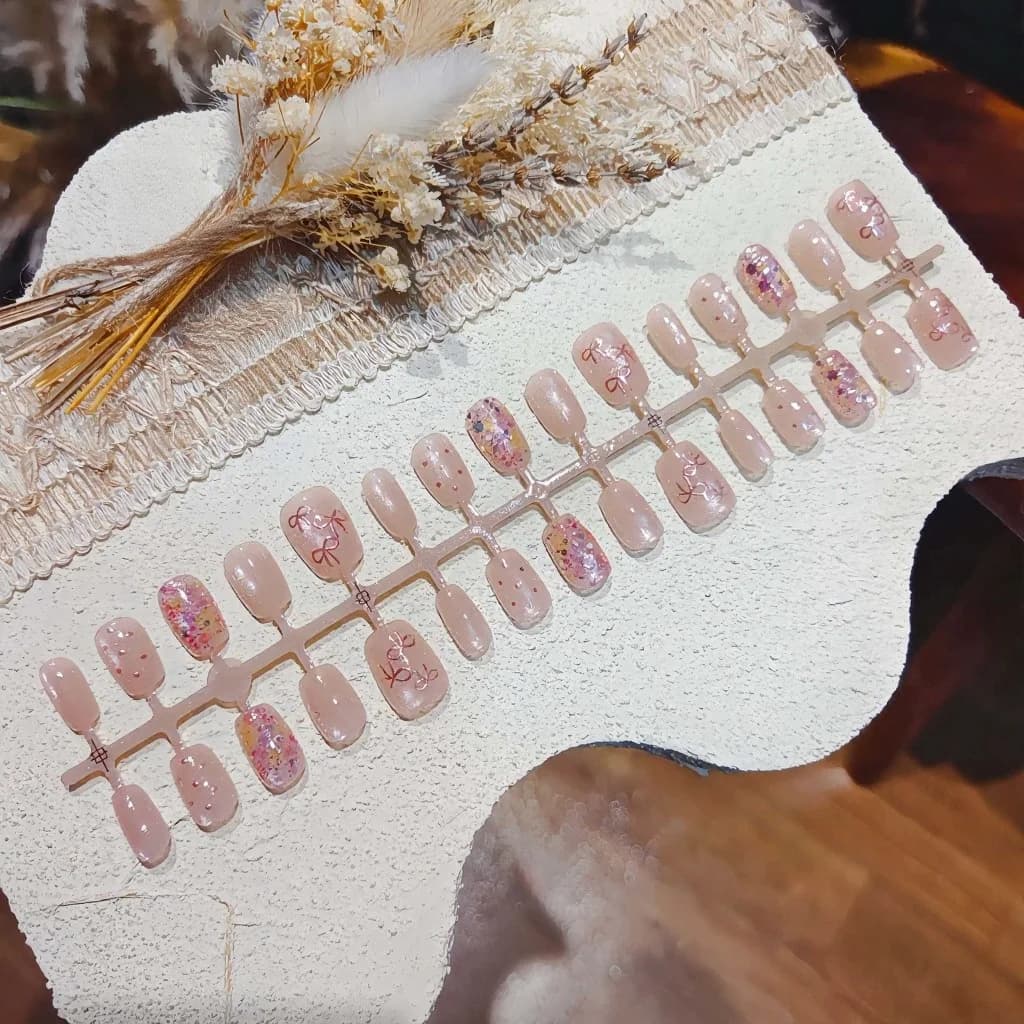 Rosa kunstnegler med sommerfugl, sløyfe og glitter