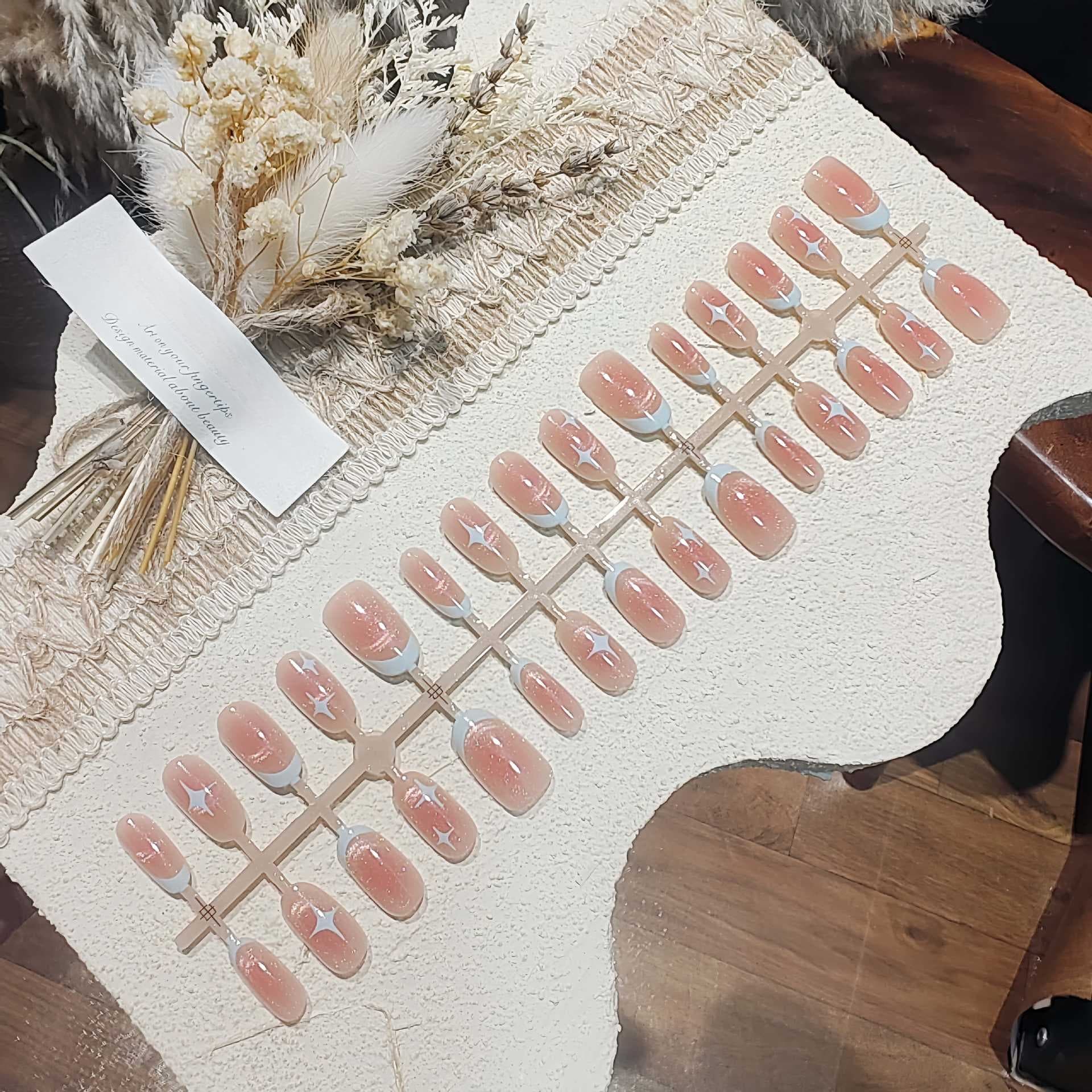 Korte ovale kattøye kunstnegler med rosa stjernehimmeldesign